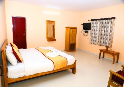 a bedroom with a bed and a tv in it at JJ Homes in Ooty