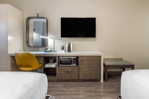a hotel room with a desk with a microwave and a tv at Cambria Hotel Downtown-Center City in Philadelphia