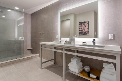 a bathroom with a sink and a mirror and a shower at Cambria Hotel Downtown-Center City in Philadelphia