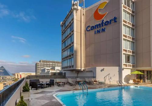 a hotel with a swimming pool in front of a building at Comfort Inn Memphis Downtown in Memphis