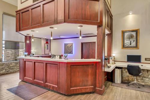 a kitchen with wooden cabinets and a counter top at Comfort Inn Murray – Salt Lake City South in Murray
