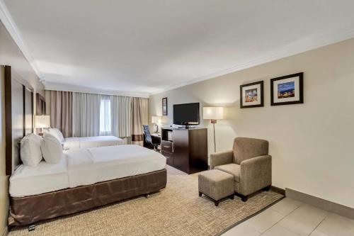 a large hotel room with a bed and a chair at Comfort Inn Murray – Salt Lake City South in Murray
