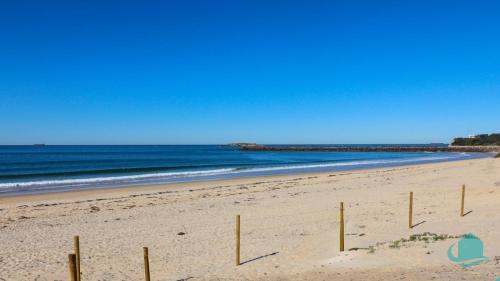 a beach with a fence in the sand and the ocean at Beach Shack - across from beach in Blacksmiths
