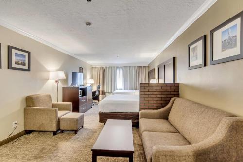 a hotel room with a couch and a bed at Comfort Inn Murray – Salt Lake City South in Murray