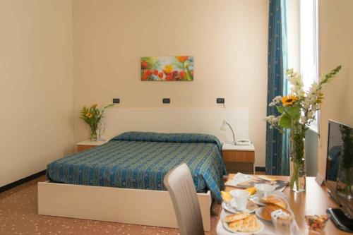 a bedroom with a bed and a table with food on it at Hotel Elisabetta in Sestri Levante
