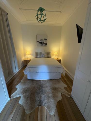 a bedroom with a bed and a rug at Pacific on Manly in Sydney
