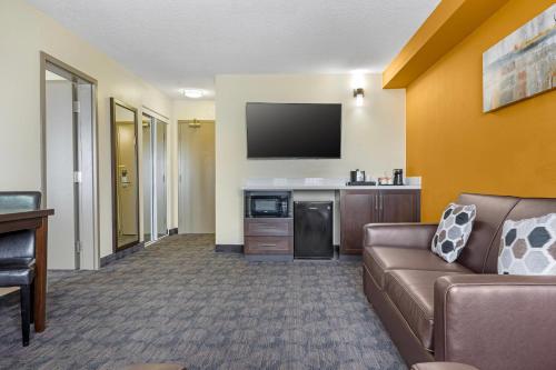 a living room with a couch and a flat screen tv at Quality Inn & Suites in Bathurst