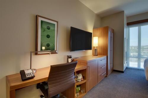 a hotel room with a desk and a television at Hyatt Place Milwaukee Downtown in Milwaukee