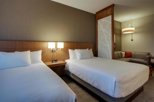 a hotel room with two beds and a couch at Hyatt Place Milwaukee Downtown in Milwaukee