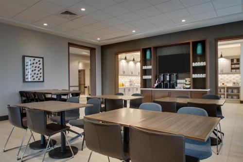 a dining room with tables and chairs and a bar at Hyatt Place Milwaukee Downtown in Milwaukee