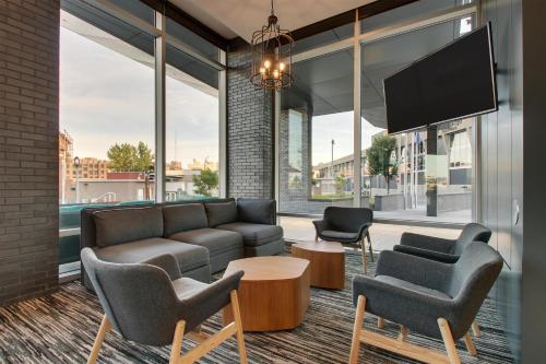 a living room with a couch and chairs and a tv at Hyatt Place Milwaukee Downtown in Milwaukee