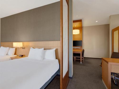 a hotel room with a bed and a desk at Hyatt Place Milwaukee Downtown in Milwaukee