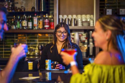 a woman sitting at a bar with two women at Hyatt Place Milwaukee Downtown in Milwaukee