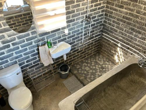 a bathroom with a sink and a toilet and a bath tub at Northern Rock Accommodation in Otjiwarongo