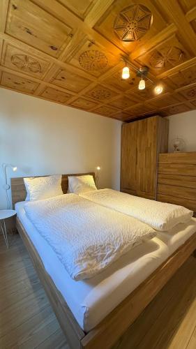 ベットマーアルプにあるam Bärgbach 1.OGの木製の天井のある部屋にある大きなベッド