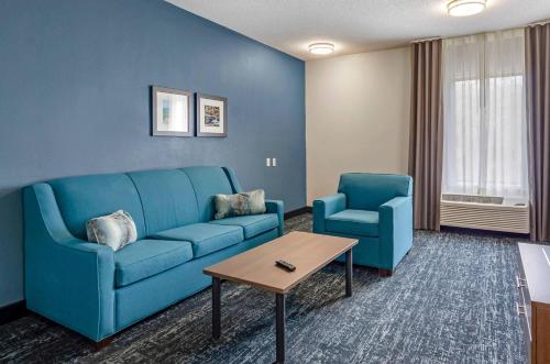 a living room with a blue couch and two chairs at Comfort Inn & Suites Troutville-Roanoke North in Troutville
