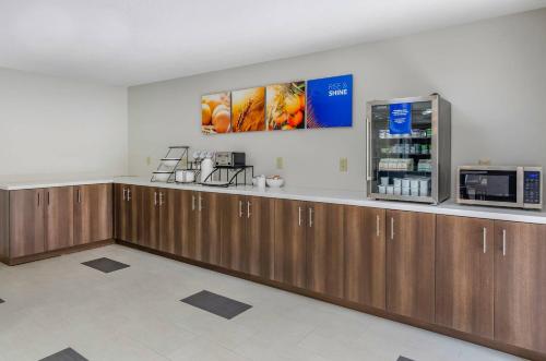 a kitchen with wooden cabinets and a microwave at Comfort Inn & Suites Troutville-Roanoke North in Troutville
