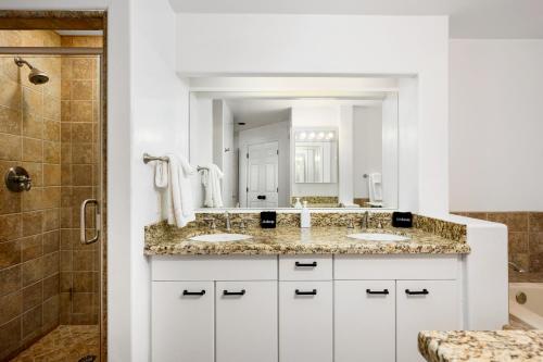 Un baño con dos lavabos y una ducha. en Exclusive Boulders Retreat near Downtown Cave Creek hiking scenic views., en Cave Creek