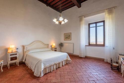 Un dormitorio con una cama blanca y una ventana. en Agriturismo La Rugiada, en Monteroni dʼArbia