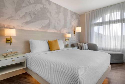 a bedroom with a large white bed and a couch at Cambria Hotel Calabasas - Malibu in Calabasas