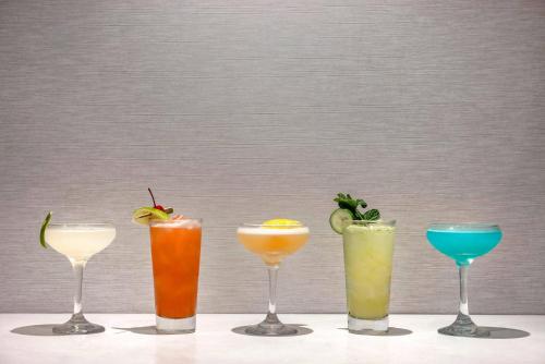 four different cocktails in wine glasses on a table at Cambria Hotel Calabasas - Malibu in Calabasas