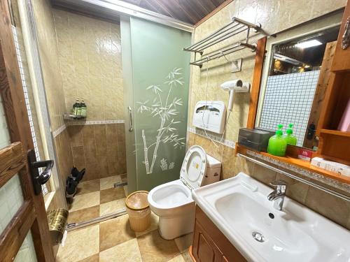 a bathroom with a toilet and a sink at Fenghuang Xiangyun Pavilion Boutique Riverside B&B in Fenghuang