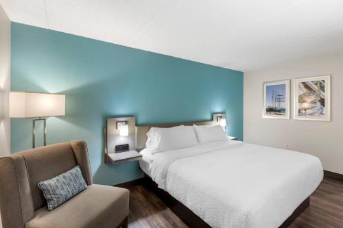 a bedroom with a large bed and a chair at The Harborview on Lake Michigan, Ascend Hotel Collection in Port Washington