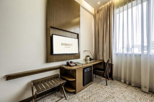a hotel room with a desk and a window at Dorsett Singapore - Newly Refurbished in Singapore