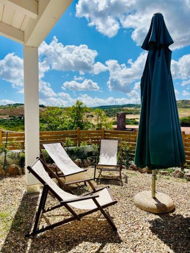 two chairs and an umbrella on a patio at Artemisia Sardegna in Tergu