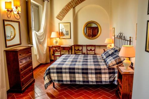 1 dormitorio con 1 cama, 2 lámparas y espejo en Adalberto - nella dimora di Fulignano, en San Gimignano