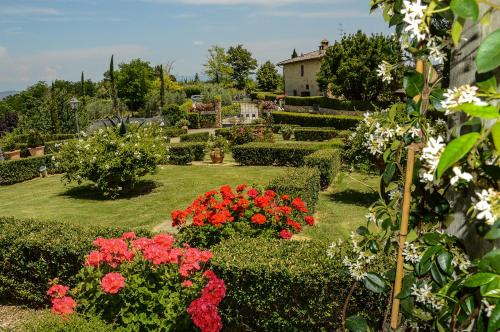 a garden with flowers and a house in the background at Adalberto - nella dimora di Fulignano in San Gimignano