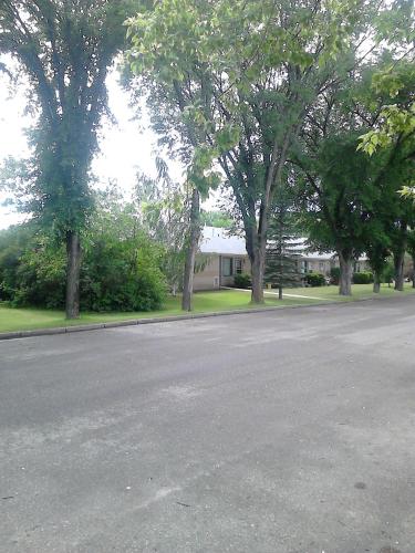 an empty street in front of a house with trees at Canora Vacation Home in Canora