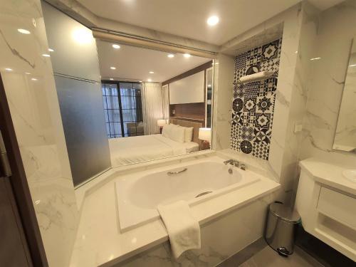 a white bathroom with a sink and a mirror at LIVIE Hanoi Ham Long in Hanoi