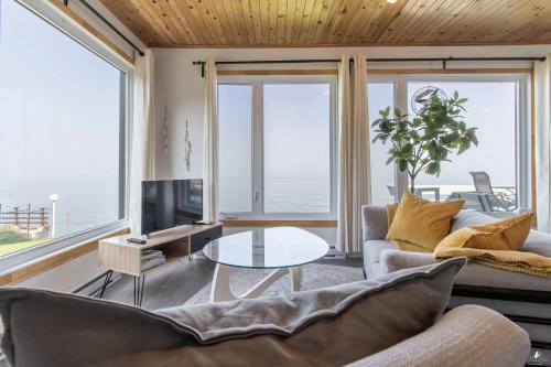 a living room with a couch and a table with a tv at Waterfront - Incredible- Le Deriveur in Saint-Antoine-Lotbinière