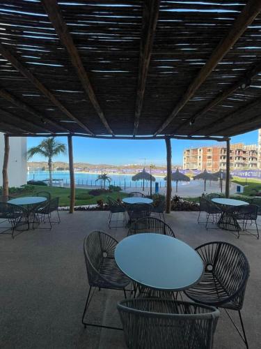 eine Terrasse mit Tischen und Stühlen und Meerblick in der Unterkunft Bluu Habitat Lagoons En Mazatlan DEPARTAMENTO in Mazatlán