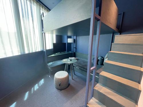 a room with a staircase leading up to a bedroom at toggle hotel suidobashi TOKYO in Tokyo