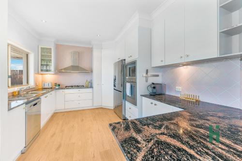 a kitchen with white cabinets and a counter top at Central Coast Moon Lake Resort in Green Point