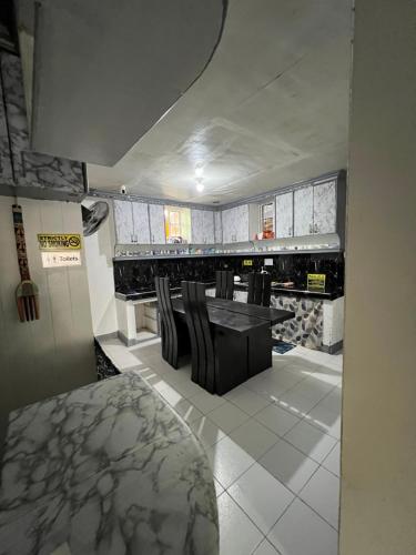 a kitchen with a table and chairs in a room at Ibañez Residence near airport sm roxas city in Roxas City