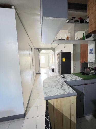 a kitchen with a counter top and a kitchen with a refrigerator at Ibañez Residence near airport sm roxas city in Roxas City