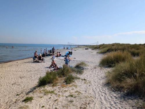 a group of people on a beach near the water at 8 person holiday home in Ålbæk in Ålbæk