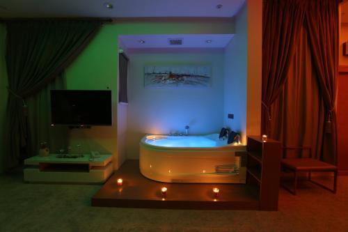 Zimmer mit einer Badewanne, einem TV und einem Zimmer mit Beleuchtung in der Unterkunft أجنحة درة Dorra Suites in Riad