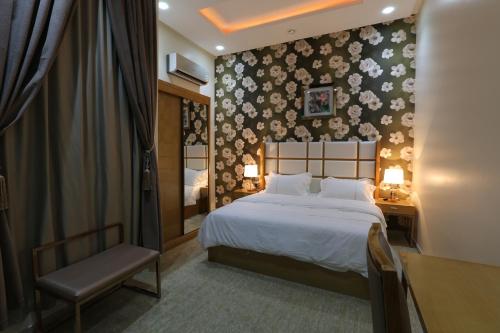 ein Hotelzimmer mit einem Bett und einem Stuhl in der Unterkunft أجنحة درة Dorra Suites in Riad