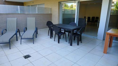 a black table and chairs on a patio at Saval Spa Aqquaria Family Complex in Salou