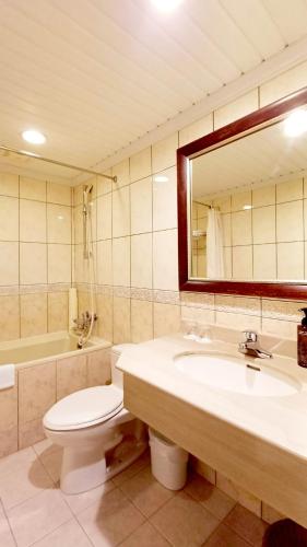 a bathroom with a sink and a toilet and a mirror at Hi-YES HOTEL TAOYUAN in Zhongli