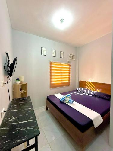 a bedroom with a bed and a table in it at Wakim’s INN in Coron