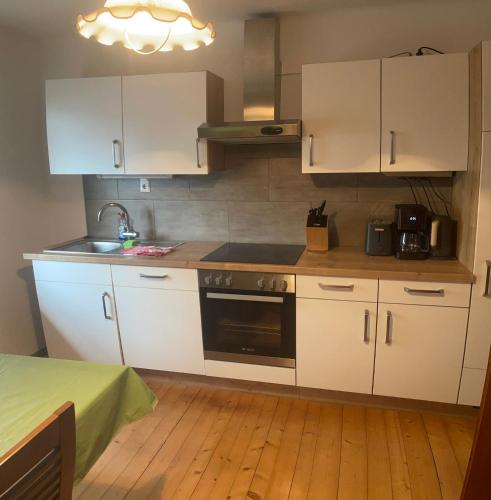 a kitchen with white cabinets and a stove top oven at Apartment an der Mühle in Mühldorf