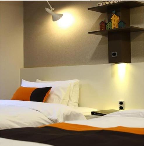 a bedroom with a bed and a light on the wall at KT&G Sangsangmadang Chuncheon Stay (Korea Quality) in Chuncheon