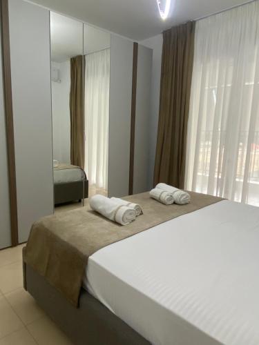 a bedroom with a large bed with towels on it at Noema Apartment 5 Maji - A Cosy Stay in Tirana in Tirana