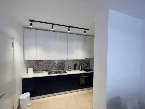a kitchen with white cabinets and a sink at Noema Apartment 5 Maji - A Cosy Stay in Tirana in Tirana