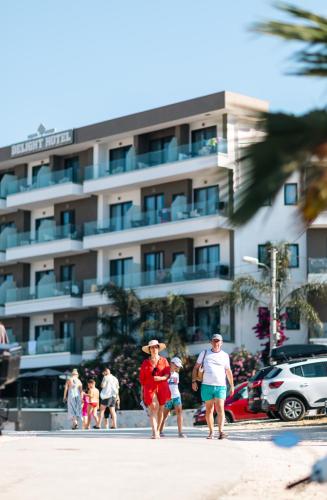 a group of people walking on the beach near a hotel at Delight Hotel in Ksamil